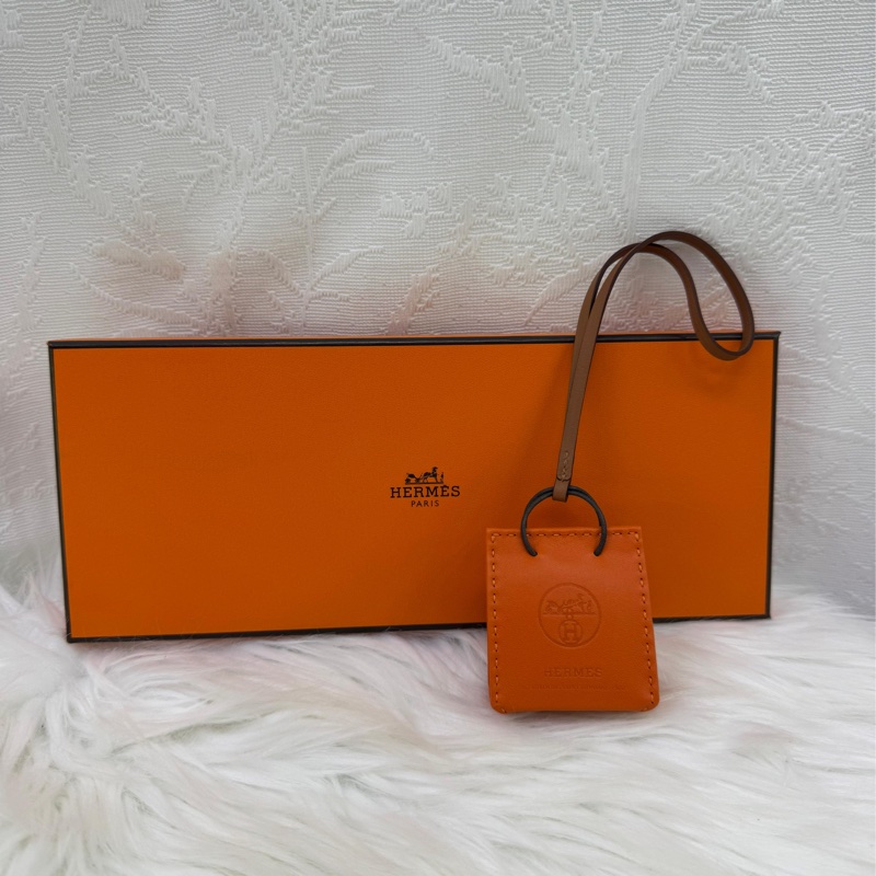 這是一個愛馬仕(Hermès)的橘色小包造型吊飾。-1