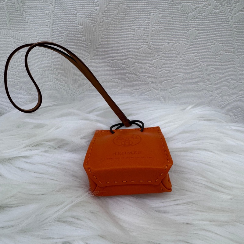 這是一個愛馬仕(Hermès)的橘色小包造型吊飾。-2