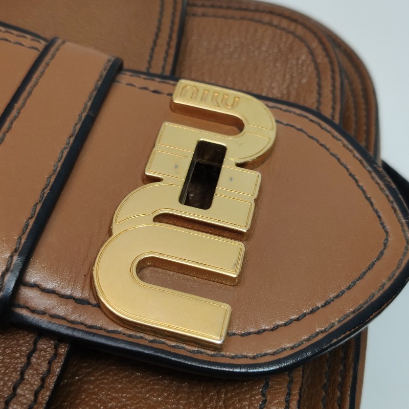 Miu Miu 牛皮羊皮純色字母Logo旋扣斜背包-11