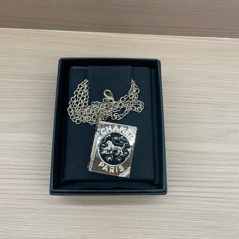Chanel香奈儿限量款雄狮双C魔法书项链,金色链条,黑色封面,狮子图案精致立体,可翻页设计,前后都有精美装饰,可做相片框,男女可戴,带盒子-0