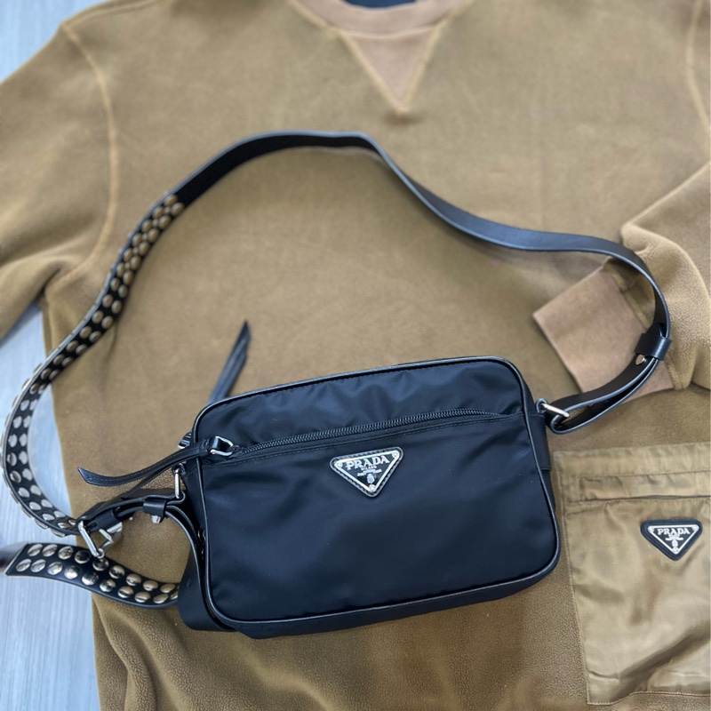 Prada 時髦收藏 絕版 經典時尚 #斜背包 #鉚釘相機包 這個現在有的話都要80,000起跳 男女都適合休閒時尚穿搭 近新 🛫獨特魅力和鉚釘時尚結合  🍏尺寸：23x15x8cm-16
