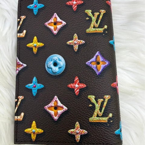 這款Louis Vuitton 袋裝萬用銀包（型號：M28282）採用帆布製造，並綴有由立體迷你甜甜圈組成的Monogram 圖案。