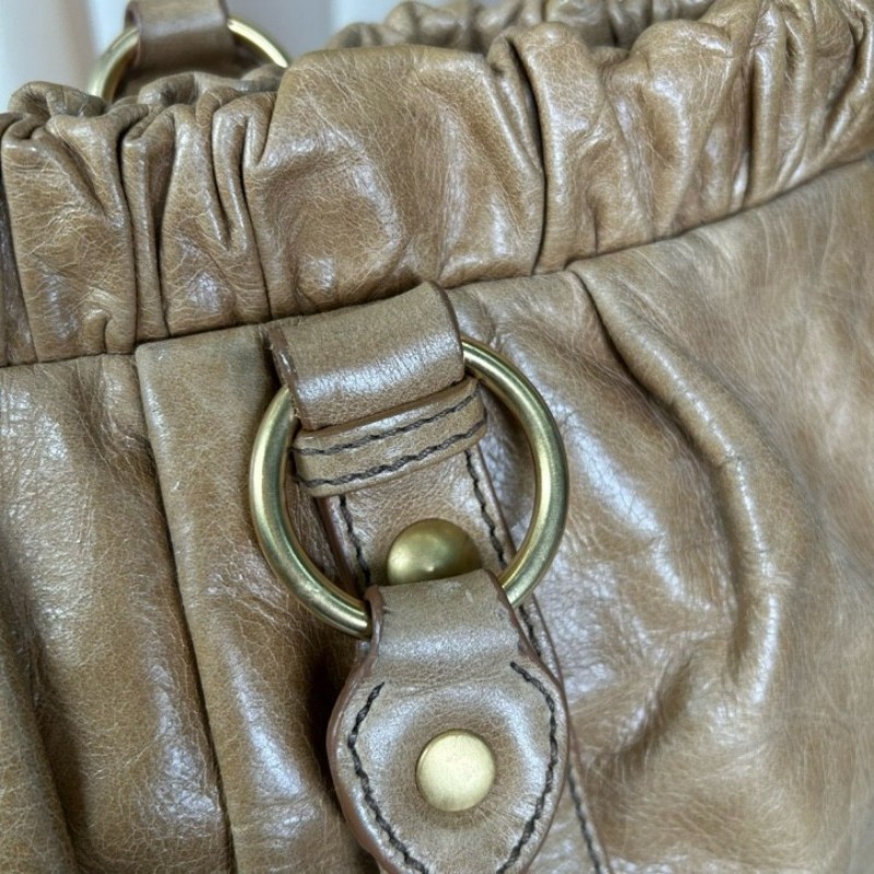 繆繆MiuMiu卡其色油蠟皮垃圾袋機車包 有肩帶 可單肩可斜挎可手提 油蠟皮質地 金屬圓環裝飾 上身就是鬆鬆垮垮垃圾袋感 容量大 日常通勤百搭實用-23