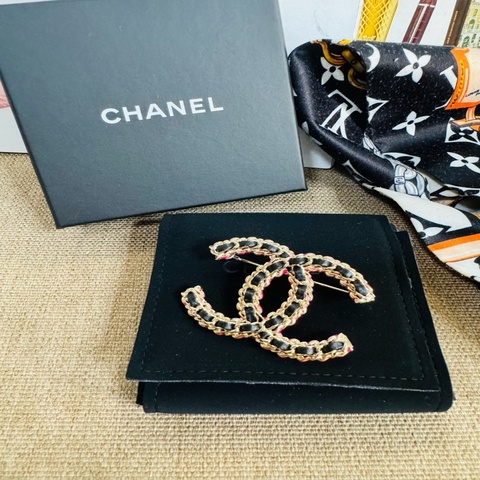 Chanel 皮穿鏈雙C胸針，經典款，黑色小牛皮穿金色鏈條，背面可以看到CHANEL字樣的底扣。